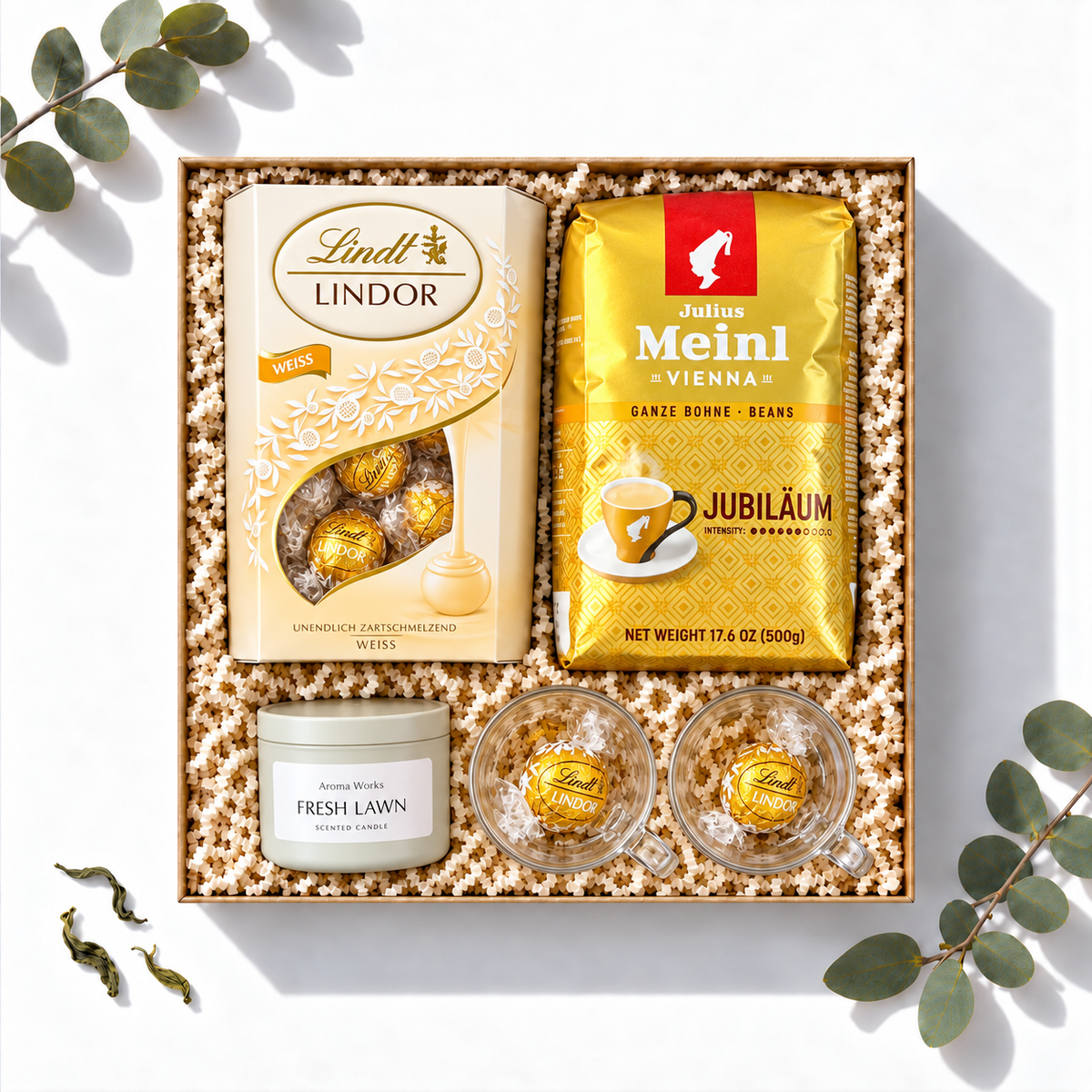 Geschenkbox Sanfter Morgenglanz mit Julius Meinl Jubiläum Kaffee, weißen Lindt Lindor Kugeln, Duftkerze und Espressogläsern, Ansicht von oben