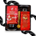 Geöffnete schwarze Geschenkbox gefüllt mit Julius Meinl Präsident Kaffeebohnen, Mirabell Mozartkugeln, zwei schwarz-weißen Espressotassen und einem goldenen Kaffeelöffel mit Clip.