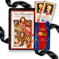 Geöffnete schwarze Geschenkbox gefüllt mit Reber Mozart-Spezialitäten, Reber Mozart-Chocoladen und Mirabell Mozarttalern auf dunklem Füllmaterial.
