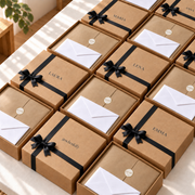 Mehrere personalisierte Geschenkboxen mit Namen und Grußkarten, ideal als Firmengeschenk für Mitarbeiter und Teams
